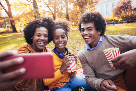 Mixed family having fun while picnicking in the park make selfie photo.の写真素材