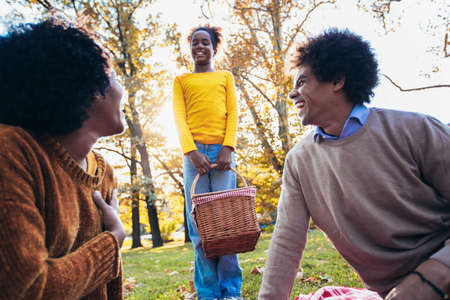 Mixed family having fun while picnicking in the parkの写真素材