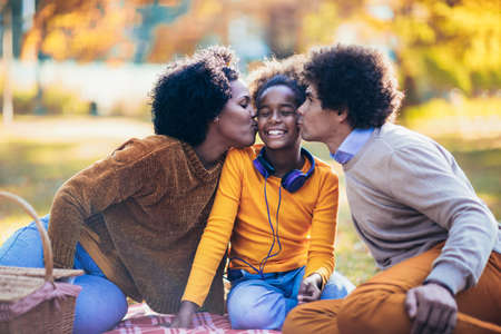 Mixed family having fun while picnicking in the parkの写真素材