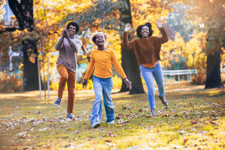 Adorable mixed race family walking in the autumn park