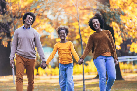 Adorable mixed race family walking in the autumn park
