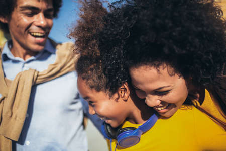 Happy young mixed race couple spending time with their daughter in shopping.