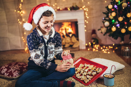 Boy packing Christmas gingerbread cookies. Christmas and New Year eve at home.