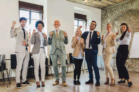 Happy business people celebrating success at company.