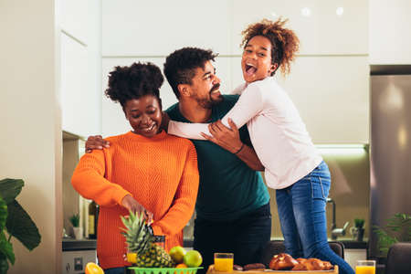 Family at home eating breakfast in kitchen together, having fun.の写真素材