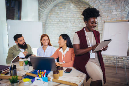 Confident female designer working on a digital tablet in  creative office spaceの写真素材