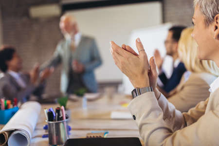 Happy colleagues applauding while attending business presentation in the office.の写真素材