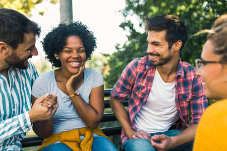 Woman with ear hearing problem having fun with her friends in the park