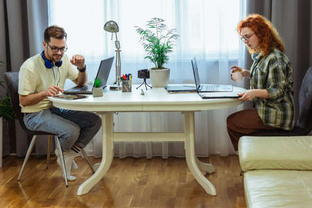 Young millennial couple working at home. Concept of freelance and remote workの写真素材
