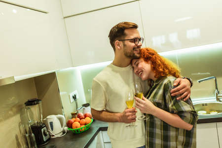 Romantic young couple cooking together in the kitchen,having a great time together, drink wine.の写真素材