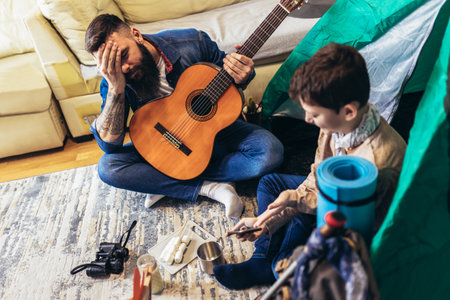 Father and son playing and having fun with camping tent in their living room. Lifestyle a new normal for social distancing in outbreak situationの写真素材
