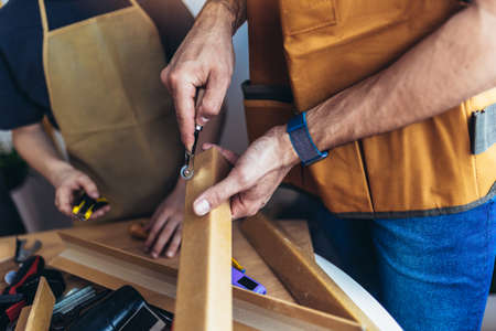 Father is teaching his son of working with wood at home. Close upの写真素材