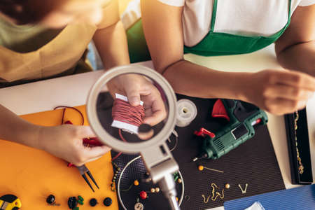 Mother and daughter accessories designers making handmade jewelry in studio workshop. Fashion, creativity and handmade concept.の写真素材