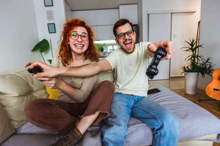 Loving couple are playing video games at home.の写真素材