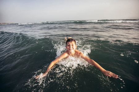 Happy child playing in the sea. Kid having fun outdoors. Summer vacation and healthy lifestyle...