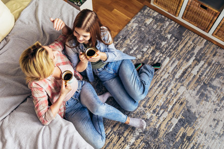Mother and daughter drink tea or coffee at home.の写真素材