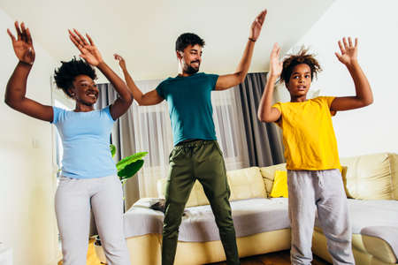 Healthy morning stretching - family doing gymnastic exercise at homeの写真素材