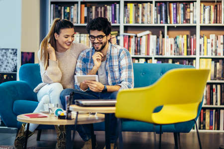 Young couple using mobile phone in a cafe.