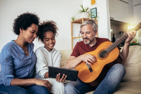 Man singing and playing guitar for his daughter and his wife.の写真素材
