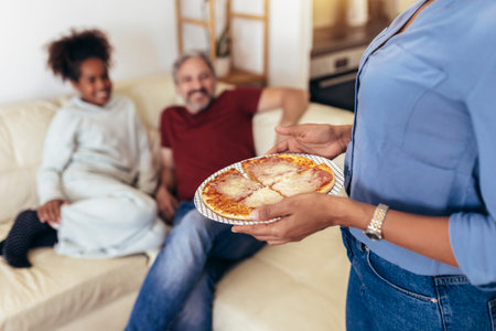 Happy family sharing pizza together at homeの写真素材