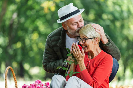 Happy senior couple having a picnic in the park