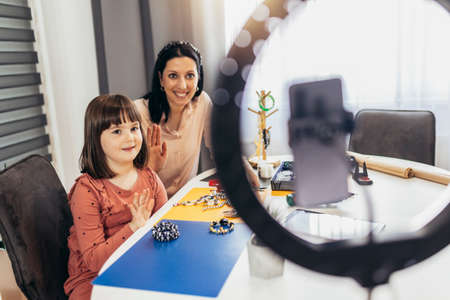 Mother and daughter accessories designers making handmade jewelry in studio workshop and recording video. Fashion, creativity and handmade concept.の写真素材