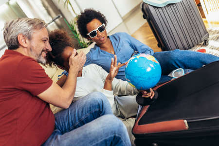 Happy family having great time and packing for summer holidaysの写真素材