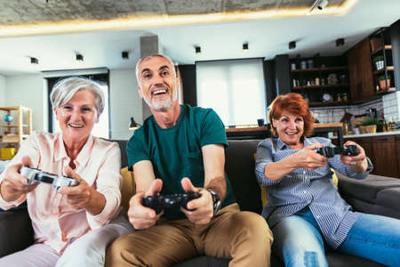 Group of middle age friends smiling happy playing video game at home.