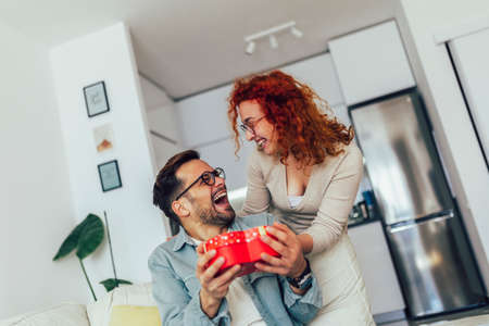 Young couple at home celebrating Valentine's Day. Romantic day together.の写真素材