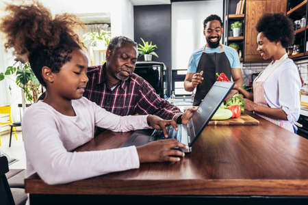 Happy multigenerational african american family make dinner together.の写真素材