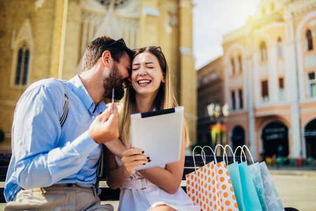 Young couple using credit card and digital tablet for online shopping outdoor.の写真素材