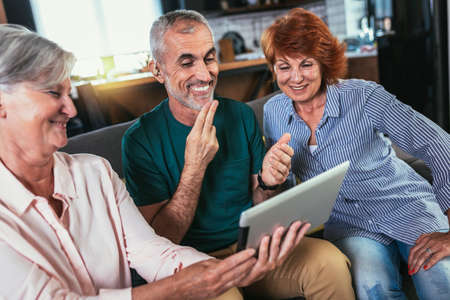 Smiling Deaf man with his friends talking using sign language on the tablets's camの写真素材