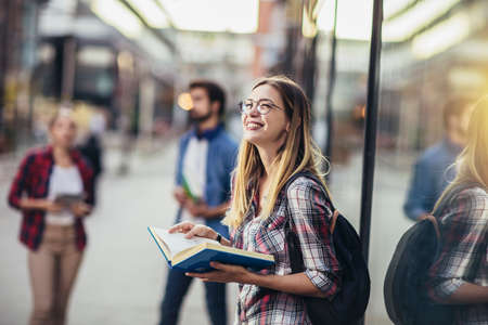 Happy university student going on a class at the university and looking at camera.の写真素材