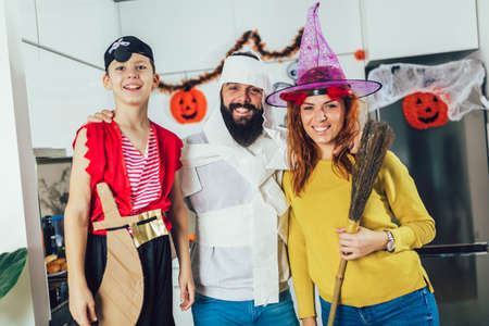 Happy family mother, father and son in costumes on a celebration of Halloweenの写真素材