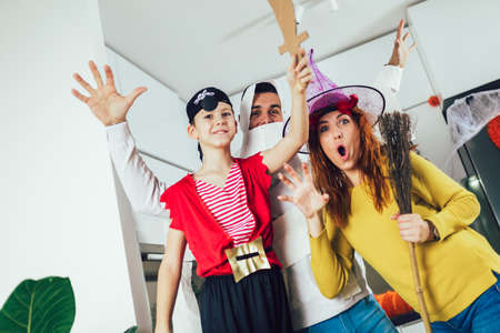 Happy family mother, father and son in costumes on a celebration of Halloweenの写真素材