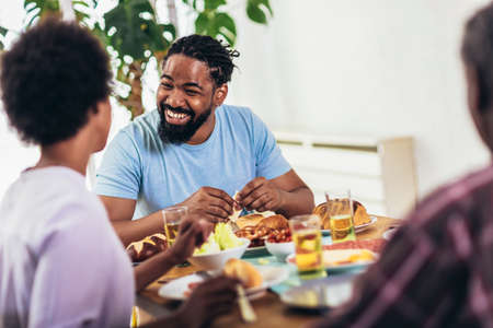 A multi-generational African-American family enjoying food at their dinner table.の写真素材