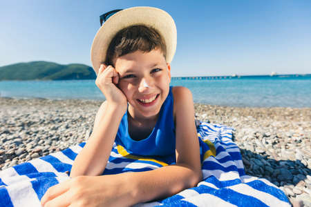 Little boy lying on beach and having fun.の写真素材