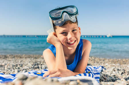 Little boy lying on beach and having fun.の写真素材