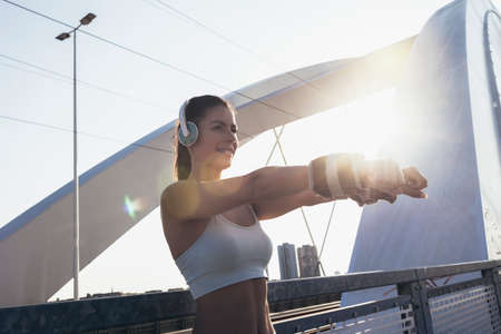 Female runner in sportswear exercising outdoors on sunny summer morning.の写真素材