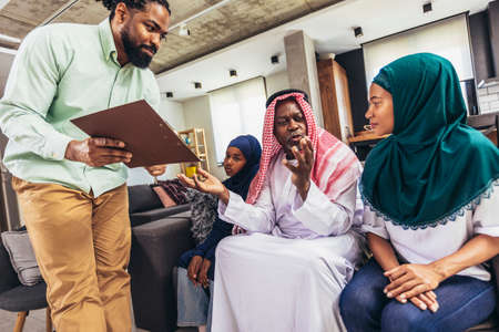 Real estate agent  discussing with a arab family who signs a contract for the purchase of an apartment.の写真素材