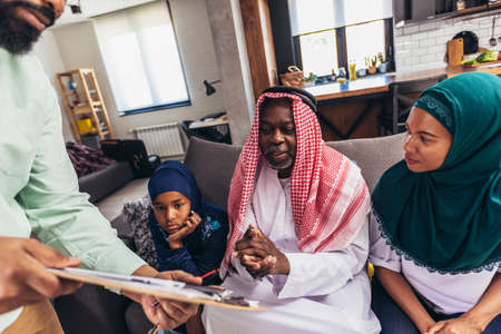 Real estate agent  discussing with a arab family who signs a contract for the purchase of an apartment.の写真素材