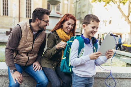 Young parents taking their little child to schoolの写真素材