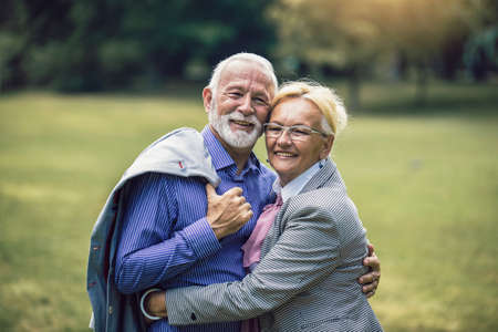 Portrait of beautiful senior couple posing in the parkの写真素材