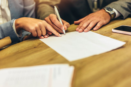 Business people negotiating a contract. Human hands working with documents at desk and signing...