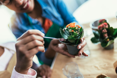 Mother and daughter planting at home, spending time together and having fun. Upcycling and recycling old tin cans, plastic, cardboard and plant seeds.の写真素材