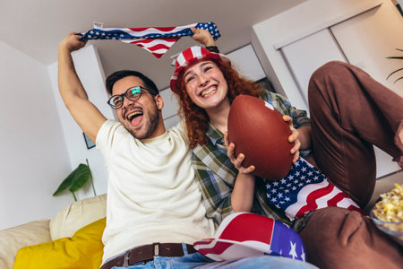 Cute couple looking excited and happy after their favorite football team scored a touchdown