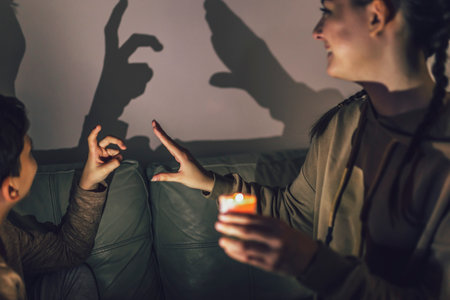 Brother and sister playing with shadows at home.の写真素材