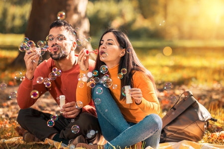 Young couple relaxing in the park with bubble blower.の写真素材