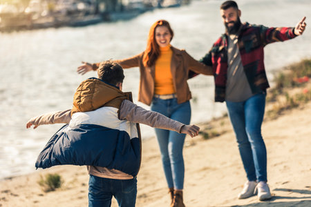 Parents and son walking near river spending vacation in countrysideの写真素材