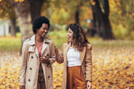 Happy woman friends walking in forest at autumn with shopping bags.の写真素材